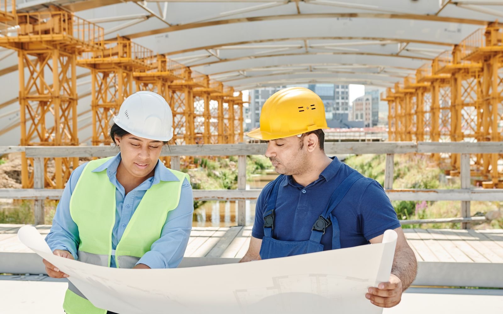 Two engineers reviewing a project drawing on site